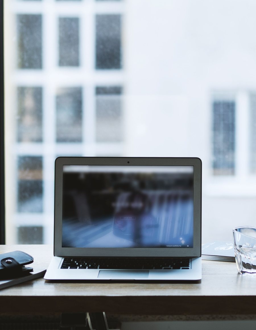 A creator's desk with a laptop, camera, and coffee — the kind of workspace Lauxon apps are built for.